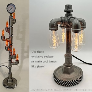 May include: Two industrial style lamps with exposed pipe fittings and Edison bulb sockets. The lamps are made with black metal pipes and have a rustic, steampunk aesthetic. The text "Use these exclusive sockets to make cool lamps like these!" is visible in the image.
