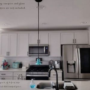 May include: Three pendant lights with black cords and blue glass insulators hanging from a white ceiling. The text in the image states: Ceiling canopies and glass insulators are not included. Buy a 3-pack of 4-foot kits at a special discounted price.
