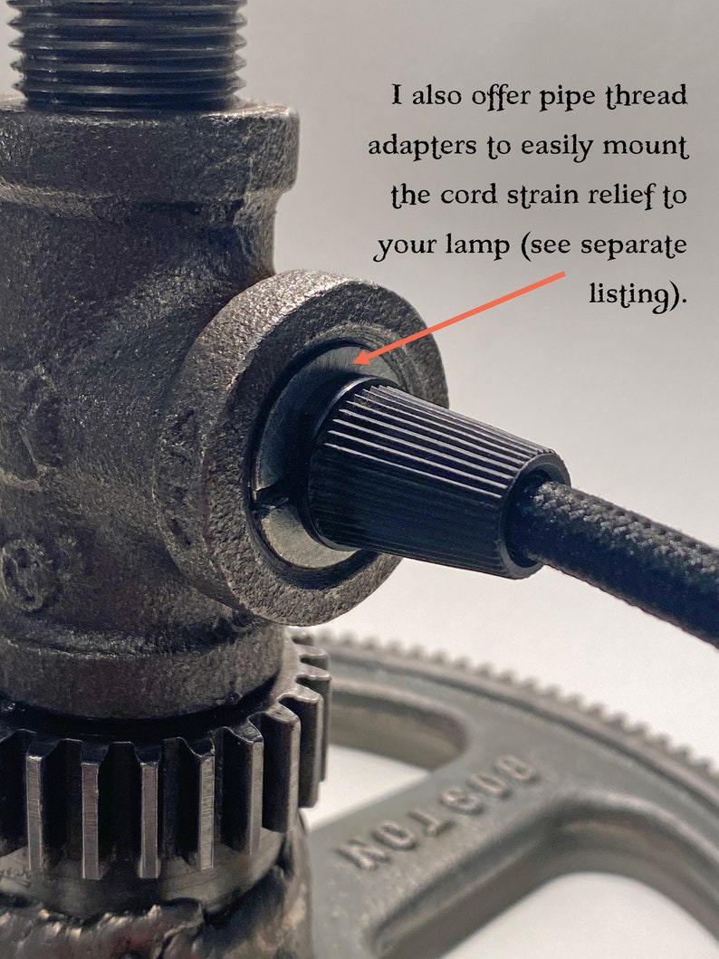 May include: A dark gray metal pipe fitting with a black ribbed cord strain relief and a black fabric-covered electrical cord. The image includes the text: I also offer pipe thread adapters to easily mount the cord strain relief to your lamp.
