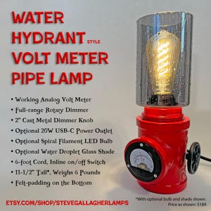 May include: A red water hydrant style pipe lamp featuring a working analog volt meter, a 2-inch cast metal dimmer knob, and a clear glass shade with a water droplet texture. The lamp includes a spiral filament LED bulb and stands 11.5 inches tall.