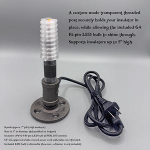May include: A black metal pipe lamp base with a circular flange, a threaded post, and a transparent threaded top. It includes a 1.5W G4 bi-pin LED bulb, a 54-inch cloth-covered power cord with an inline switch, and supports insulators up to 5 inches high.