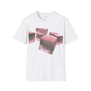 May include: White t-shirt featuring a graphic of several pinkish-purple ice cubes. The word "ICE" is printed in blue below the cubes. The shirt has a crew neck and short sleeves.