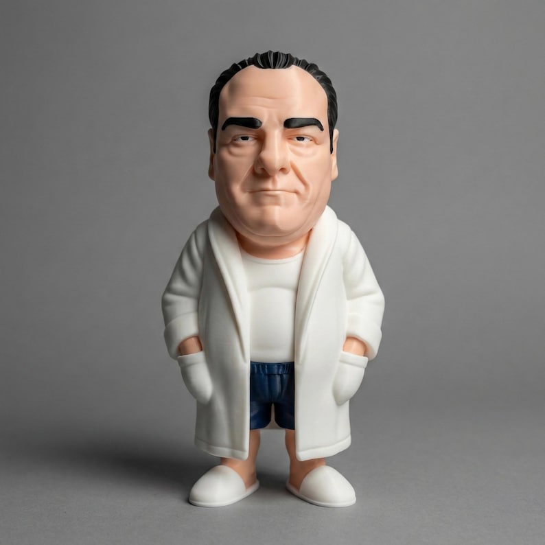 A detailed Tony Soprano collectible figure wearing his iconic white bathrobe and blue boxers, standing against a clean grey background.