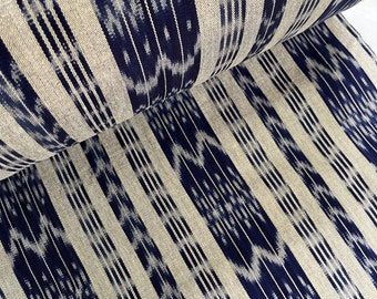 May include: Close-up of a fabric with a white and blue striped pattern. The fabric has a subtle ikat design with a repeating pattern of small, white diamonds.