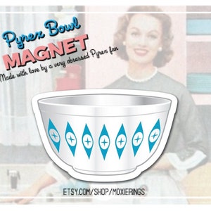 May include: A white Pyrex bowl magnet with a blue and white geometric design. The magnet is shaped like a Pyrex bowl and has the text "Pyrex Bowl Magnet" and "Made with love by a very obsessed Pyrex fan" on it.