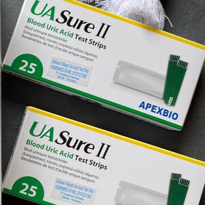 Pode incluir: Duas caixas de tiras de teste de &aacute;cido &uacute;rico no sangue UA Sure II s&atilde;o exibidas. Cada caixa branca tem texto verde e azul e cont&eacute;m 25 tiras de teste. As caixas tamb&eacute;m incluem o logotipo ApexBio.