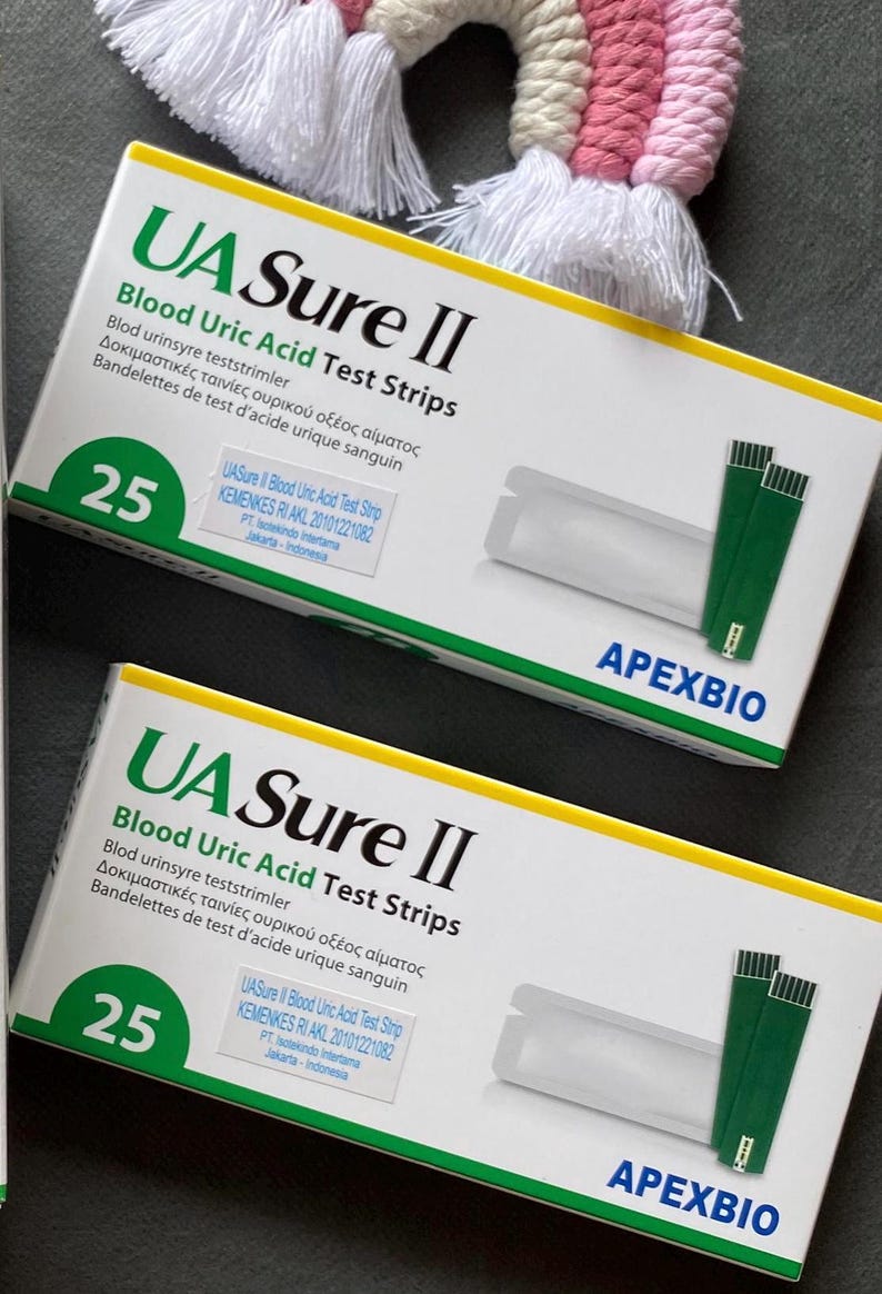 Pode incluir: Duas caixas de tiras de teste de &aacute;cido &uacute;rico no sangue UA Sure II s&atilde;o exibidas. Cada caixa branca tem texto verde e azul e cont&eacute;m 25 tiras de teste. As caixas tamb&eacute;m incluem o logotipo ApexBio.
