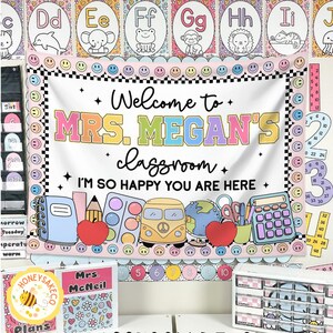 K&ouml;nnte beinhalten: Ein Klassenbanner mit dem Text "Welcome to MRS. MEGAN'S classroom. I'M SO HAPPY YOU ARE HERE." Das Banner zeigt farbenfrohe Illustrationen von Schulmaterialien, einem Schulbus und einem Globus. Das Banner ist von einem schwarz-wei&szlig; karierten Rand umgeben.