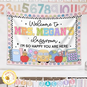 K&ouml;nnte beinhalten: Ein Klassenbanner mit dem Text "Welcome to MRS. MEGAN'S classroom. I'M SO HAPPY YOU ARE HERE." Das Banner hat einen rosa Rand mit Smiley-Gesichtern und schwarz-wei&szlig; karierten Akzenten. Illustrationen von Schulmaterialien sind enthalten.