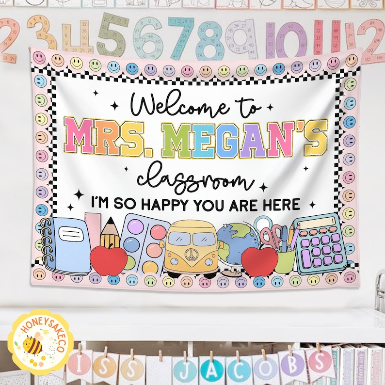 K&ouml;nnte beinhalten: Ein Klassenbanner mit dem Text "Welcome to MRS. MEGAN'S classroom. I'M SO HAPPY YOU ARE HERE." Das Banner hat einen rosa Rand mit Smiley-Gesichtern und schwarz-wei&szlig; karierten Akzenten. Illustrationen von Schulmaterialien sind enthalten.