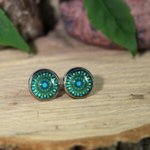 May include: A pair of silver stud earrings with a blue and green mandala design.