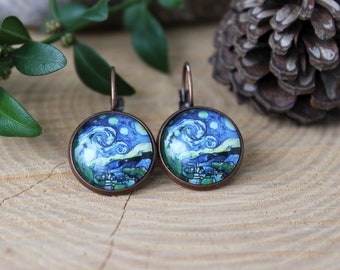 May include: A pair of copper-toned earrings with a round glass cabochon featuring a reproduction of Vincent van Gogh's "The Starry Night" painting.