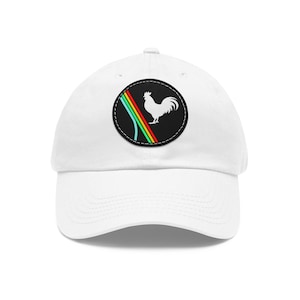 May include: White baseball cap with a black circular patch featuring a white rooster silhouette and a rainbow design. The cap has a curved brim and an adjustable strap for a comfortable fit. A stylish accessory for casual wear.