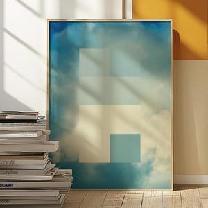 May include: A framed art print featuring a geometric design against a cloudy sky backdrop. The artwork showcases a series of rectangular shapes in varying shades of blue and off-white. The print is encased in a thin, natural wood frame, adding a touch of warmth to the cool color palette.