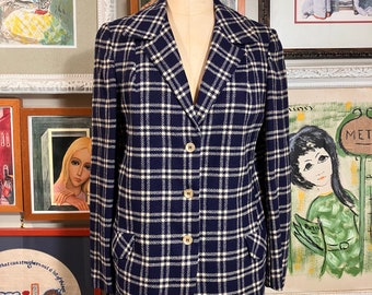 May include: A navy blue blazer with a white and black plaid pattern. The blazer has a notched collar, four button closure, and two flap pockets.