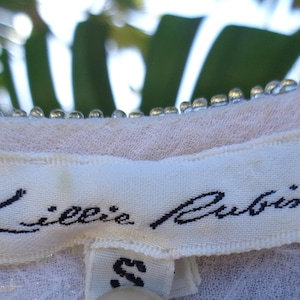 May include: White clothing label with black text that reads "Lillie Rubin" and a size "S" tag.