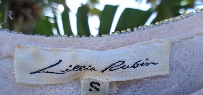 May include: White clothing label with black text that reads "Lillie Rubin" and a size "S" tag.