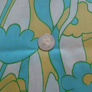 May include: A fabric with a repeating pattern of stylized flowers in shades of blue, green, and yellow. The fabric is white with a subtle sheen.