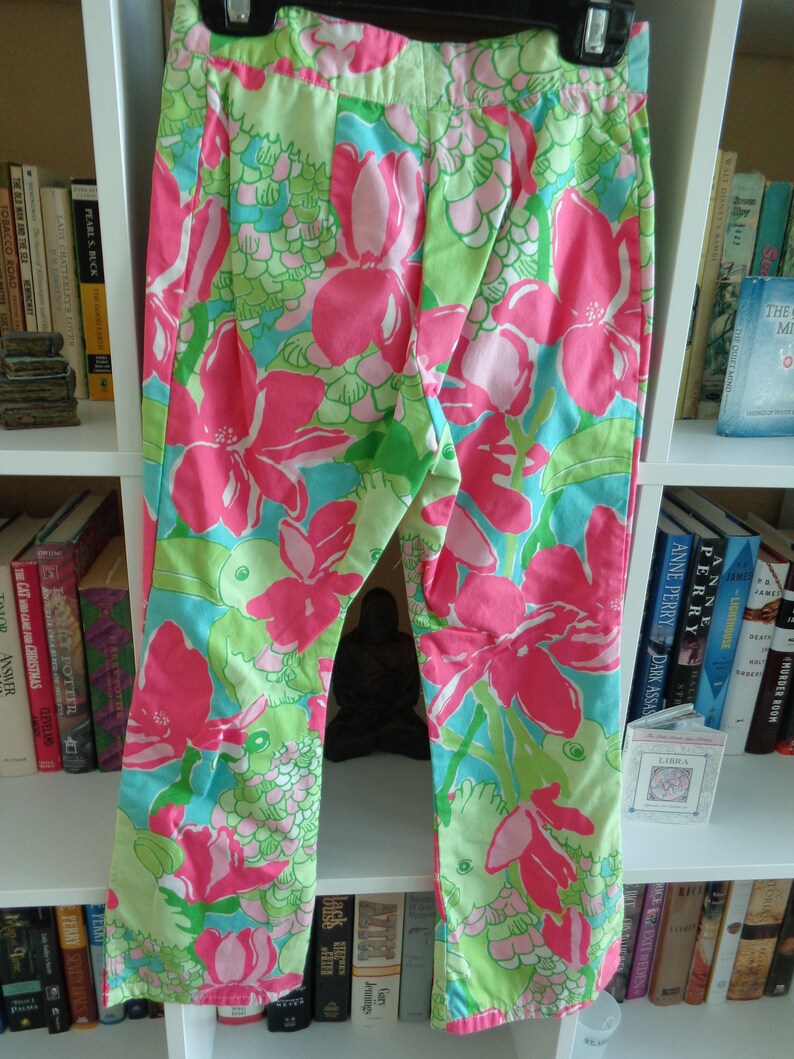 May include: Pink and green floral print pants with a wide leg and a high waist.