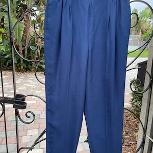 May include: A pair of dark blue, straight-leg pants with a wide waistband and a slightly cropped length.
