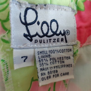 May include: A white tag with the Lilly Pulitzer logo and size 7. The tag lists the fabric content as 100% cotton for the shell and 65% polyester and 35% cotton for the lining. The tag also states "Made in Philippines" and provides a care instruction.