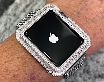 May include: A silver Apple Watch with a diamond-encrusted band and bezel. The watch face is black with the Apple logo displayed.