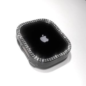 May include: Black Apple Watch case with a clear, sparkly rhinestone border.
