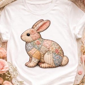 Pode incluir: T-shirt branco com um design de coelho de patchwork. O coelho é feito de vários tecidos florais e estampados em cores pastel, com um olho preto e um contorno costurado castanho. O design está centrado na t-shirt.