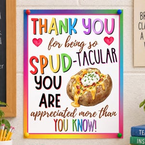 May include: A rectangular poster with a rainbow border featuring the text THANK YOU for being so SPUD-TACULAR YOU ARE appreciated more than YOU KNOW! The design includes two red hearts and a watercolour illustration of a baked potato with cheese.
