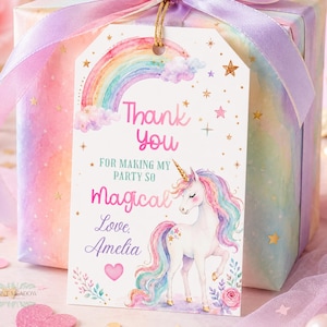 May include: A rectangular gift tag with a rainbow, stars, and a unicorn illustration. The text reads: Thank you for making my party so magical Love, Amelia. The tag is attached with a gold string to a gift box wrapped in pastel paper with a lavender ribbon.
