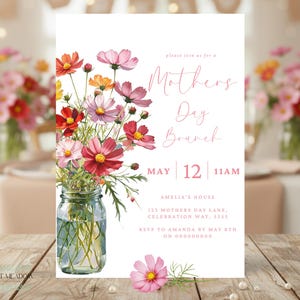 Peut inclure: Une invitation blanche pour un brunch de la fête des mères avec un motif floral. La carte présente une illustration à l'aquarelle de fleurs de cosmos colorées dans un bocal Mason. Le texte indique "Mothers Day Brunch" et comprend la date, l'heure et le lieu.