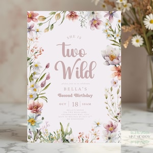 May include: A floral-themed invitation card with the text "She is Two Wild" in a mauve script. The card is framed by watercolor flowers in shades of pink, white, and green. The details include the name "Bella" and the date of the second birthday.