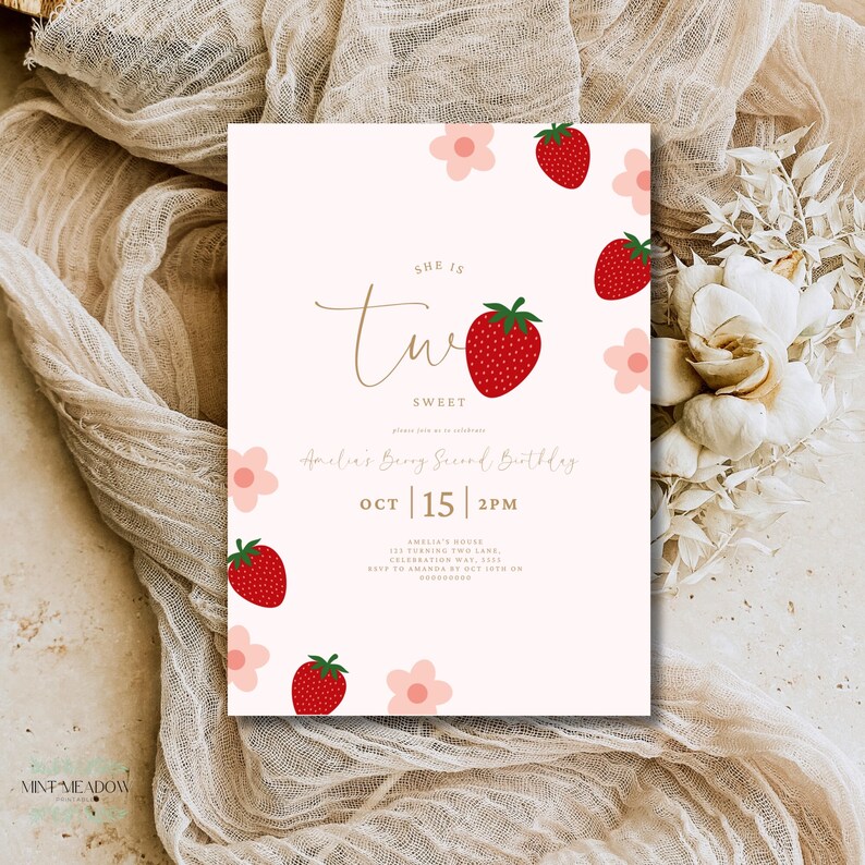 Op de afbeelding: Een lichtroze verjaardagsuitnodiging met aardbeien- en bloemillustraties. De tekst luidt "She is Two Sweet" met de verjaardagsdetails: Amelia's Berry Second Birthday, 15 oktober, 14:00 uur.
