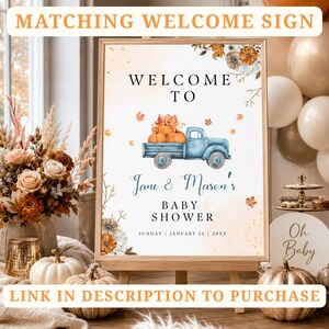 May include: A rectangular baby shower welcome sign in a wooden frame featuring a watercolor illustration of a blue pickup truck carrying pumpkins, surrounded by autumn leaves and flowers, with the text Jane & Mason's BABY SHOWER.