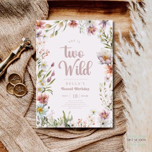 May include: A floral-themed birthday invitation with the text "She is Two Wild" in a soft, mauve script. The invitation is framed by watercolor flowers in shades of pink, white, and green. The details include the date, time, and location.