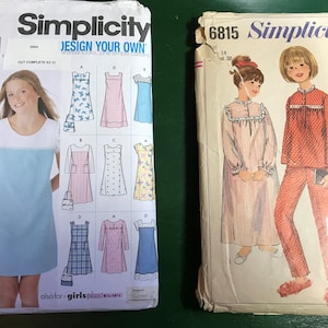 May include: Two Simplicity sewing pattern packages. The first package is for a girls' dress and has a blue and white butterfly design. The second package is for a girls' nightgown and pajamas and has a red and white polka dot design.
