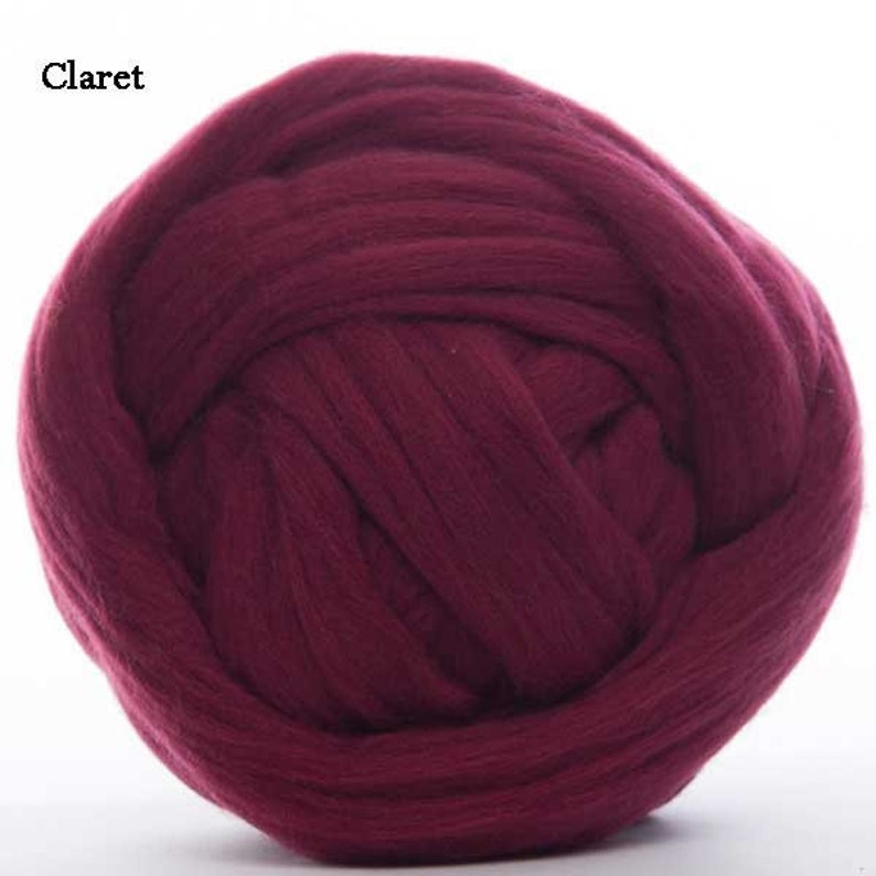 Puede incluir: Una gran bola de vell&oacute;n de lana color clarete. El color burdeos intenso es uniforme en toda la fibra, que parece suave y esponjosa. La palabra "Claret" est&aacute; impresa en blanco en la esquina superior izquierda.