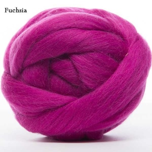 Puede incluir: Primer plano de una bola de roving de lana fucsia. El texto "Fuchsia" est&aacute; en la esquina superior izquierda. La lana est&aacute; bien enrollada, mostrando la textura de las fibras. Esta lana es adecuada para varios proyectos de arte textil.
