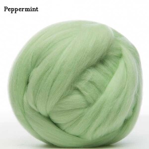 May include: A ball of light green wool roving, a type of fiber used for felting and spinning.