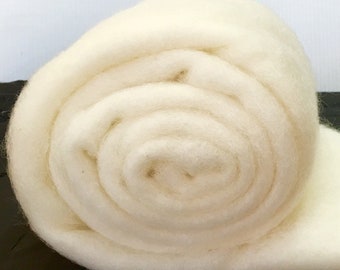 May include: A close-up of a roll of white wool roving. The wool is soft and fluffy, and it is perfect for felting, spinning, or other fiber crafts.