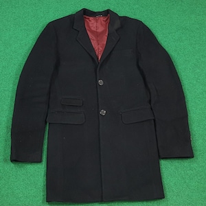 May include: A black overcoat with a red lining. The coat features two front pockets, a two-button fastening, and a notched lapel. The coat is made from a wool-like fabric.