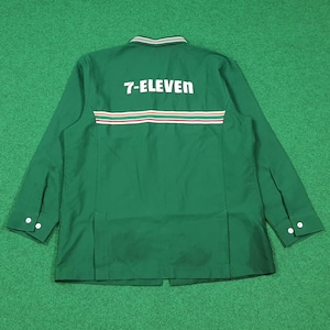 Puede incluir: Camisa de trabajo verde de manga larga con el texto "7-ELEVEN" en blanco en la espalda. La camisa tiene un diseño de rayas blancas, rojas y naranjas en la espalda. El cuello tiene un diseño de rayas blancas y verdes.