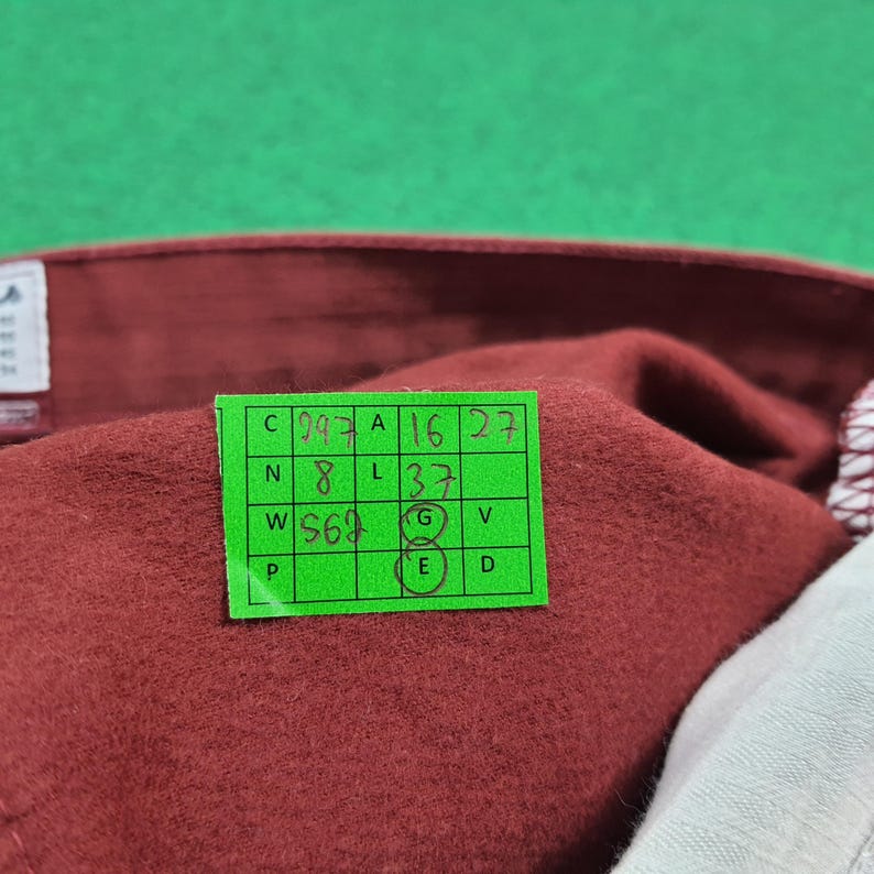 May include: A white ceramic mug with a black handle and the text "But First, Coffee" in a black, handwritten-style font. The mug is on a white surface.