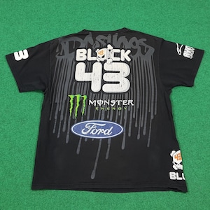May include: A black short-sleeve t-shirt featuring a large graphic print with the text BLOCK 43, a skull icon, a Monster Energy logo, and a Ford logo. The design includes grey paint drip effects, the number 3 on the sleeve, and additional branding.
