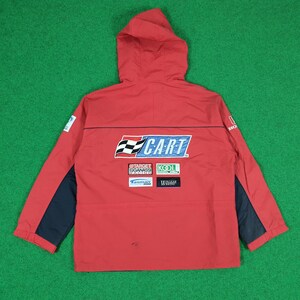 May include: A red hooded jacket with dark blue panels on the sleeves. The back features a large CART logo with a checkered flag, along with sponsor patches for Target Ganassi Racing, Kool, Tasman Motorsports, and Walker Racing, plus a Honda logo.