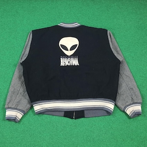 May include: Black and gray varsity jacket with an alien head graphic and the word "BESCHWA" in white. The jacket has gray sleeves, a black body, and white and gray striped trim at the cuffs, collar, and hem.