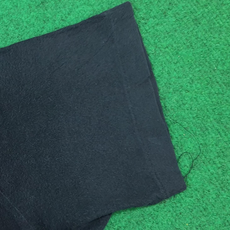 May include: A solid black short sleeve t-shirt featuring a clean, plain design with a standard hemmed sleeve edge. The fabric appears to be a soft, opaque cotton material with a consistent dark black color throughout the entire visible garment surface.