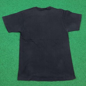 May include: A solid black short-sleeved t-shirt with a crew neckline. The garment is laid flat, displaying a plain, unadorned back side with a standard hemline at the sleeves and the bottom edge, featuring a consistent dark fabric throughout.