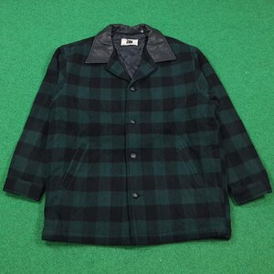 May include: A green and black plaid jacket with a black leather collar. The jacket has a button-up front and two front pockets. The jacket is made of a wool-like material.