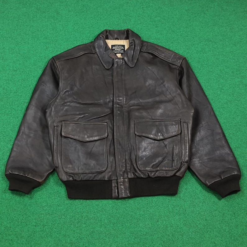 Puede incluir: Una chaqueta de aviador de cuero marr&oacute;n oscuro con cuello en punta, mangas largas con pu&ntilde;os acanalados y dobladillo acanalado. La chaqueta incluye dos bolsillos delanteros grandes con solapas abotonadas y cierre central de cremallera con etiqueta.